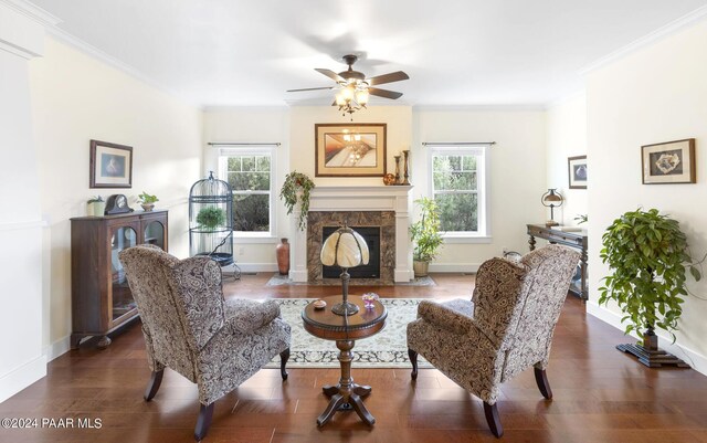 sitting room with ornamental molding, dark wood-type flooring, and a wealth of natural light