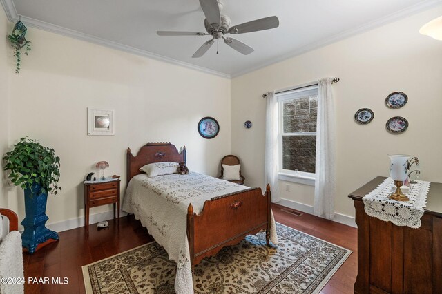 bedroom with ornamental molding, dark wood finished floors, visible vents, and baseboards