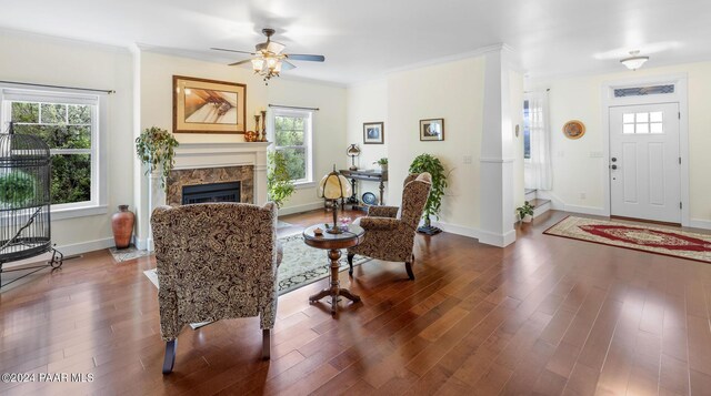 foyer entrance with crown molding, a fireplace, dark wood finished floors, ceiling fan, and baseboards