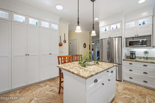 kitchen featuring white cabinets, appliances with stainless steel finishes, glass insert cabinets, and a center island