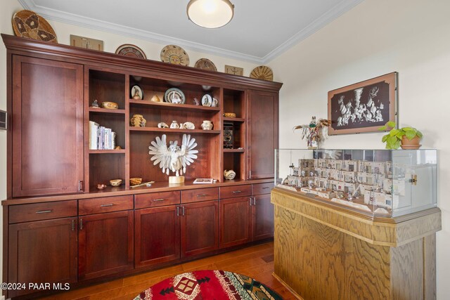 bar featuring crown molding and light wood-style flooring