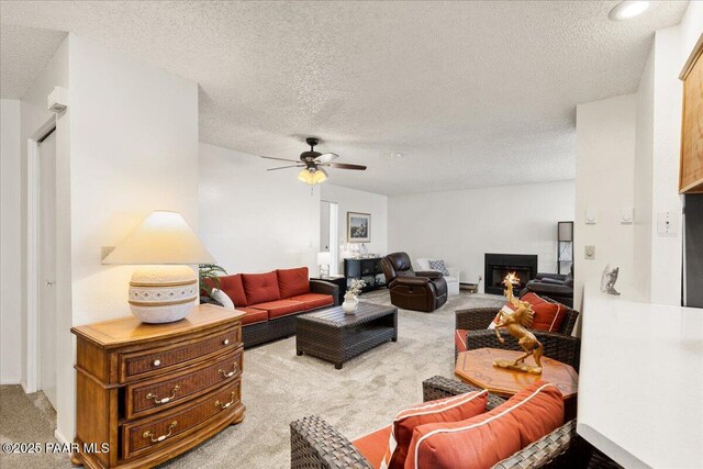 333 W Leroux St Unit D4, Prescott, AZ 86303 - carpeted living room featuring a textured ceiling, a warm lit fireplace, and a ceiling fan