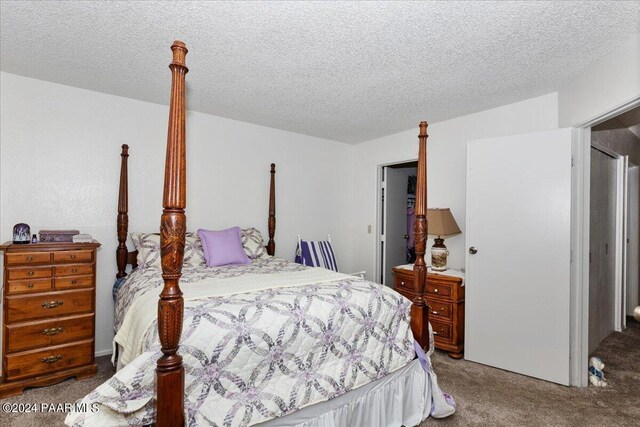 bedroom with carpet and a textured ceiling