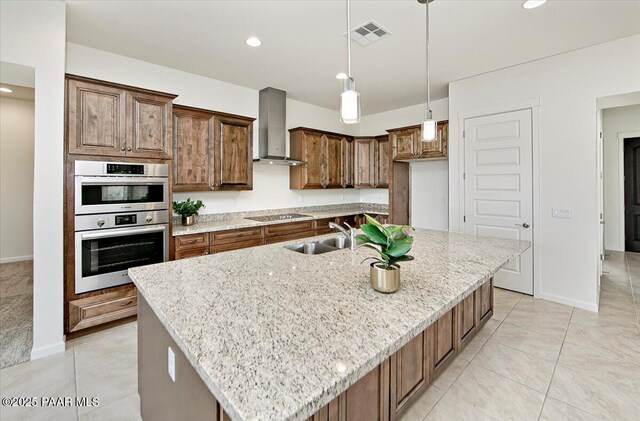kitchen featuring black electric cooktop, a sink, wall chimney range hood, light stone counters, and stainless steel double oven