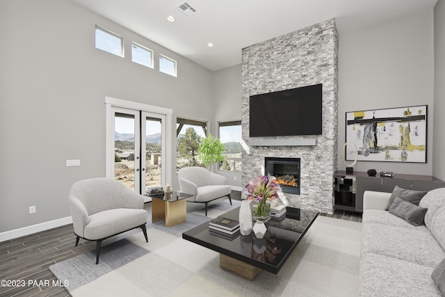 living room featuring a stone fireplace and french doors