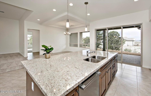 kitchen featuring open floor plan, a healthy amount of sunlight, stainless steel dishwasher, and a sink