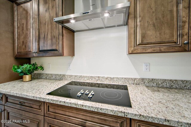 kitchen with black electric stovetop, dark brown cabinets, and ventilation hood