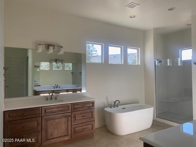 bathroom with tile patterned floors, vanity, and shower with separate bathtub