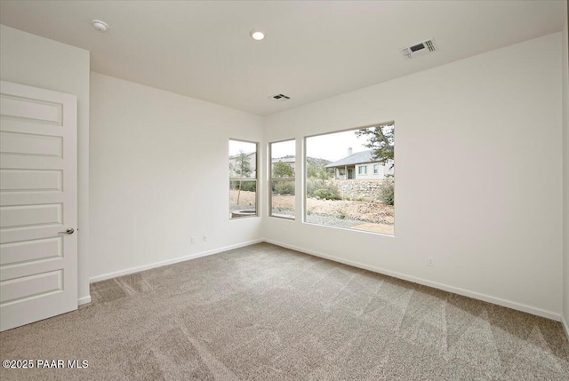 empty room with visible vents, baseboards, and carpet flooring