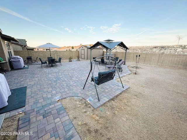 view of patio with a gazebo and a storage unit