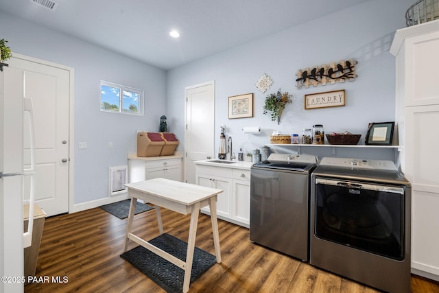 laundry area with sink, dark wood-type flooring, cabinets, and independent washer and dryer