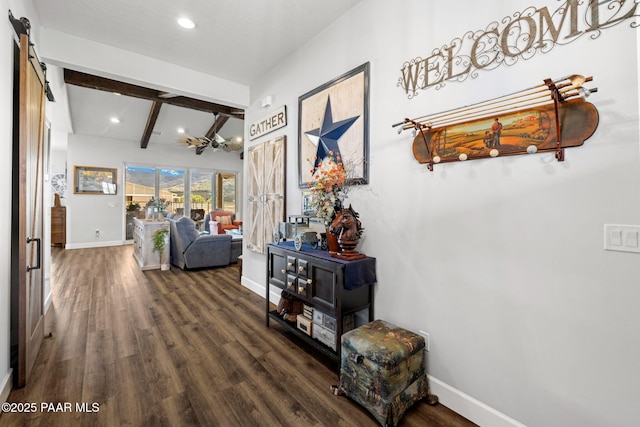 hall with a barn door, beam ceiling, and dark hardwood / wood-style floors