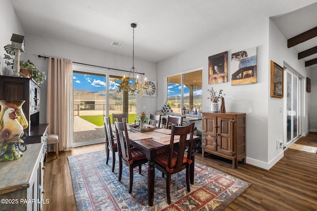 dining area featuring dark hardwood / wood-style floors and an inviting chandelier