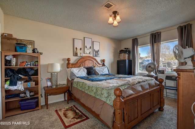 bedroom with carpet, visible vents, and a textured ceiling