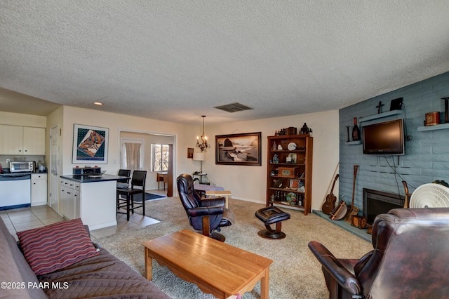 living area with a textured ceiling, light tile patterned flooring, a notable chandelier, visible vents, and a brick fireplace