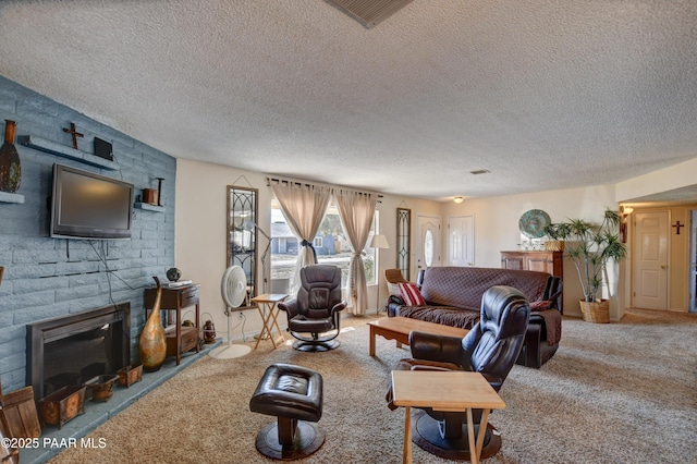 carpeted living room with a textured ceiling, a brick fireplace, and visible vents