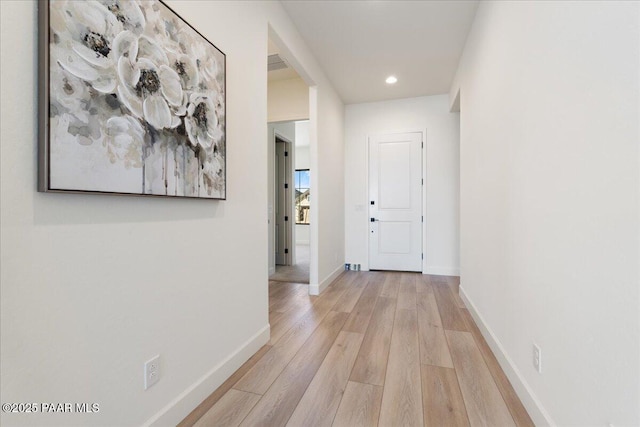 corridor with light wood-style floors, visible vents, baseboards, and recessed lighting