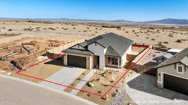 view of front facade featuring decorative driveway, a desert view, and a mountain view