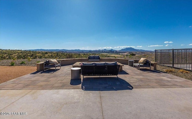 view of patio with a mountain view and fence