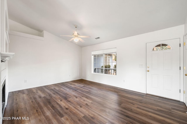 unfurnished living room featuring visible vents, dark wood finished floors, lofted ceiling, a fireplace, and ceiling fan