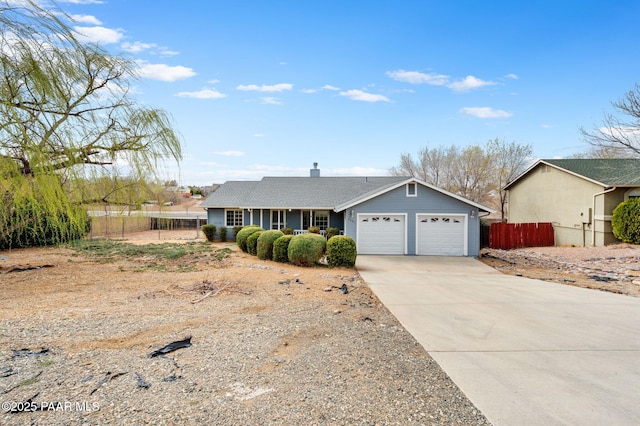 ranch-style home featuring concrete driveway, an attached garage, fence, and a chimney