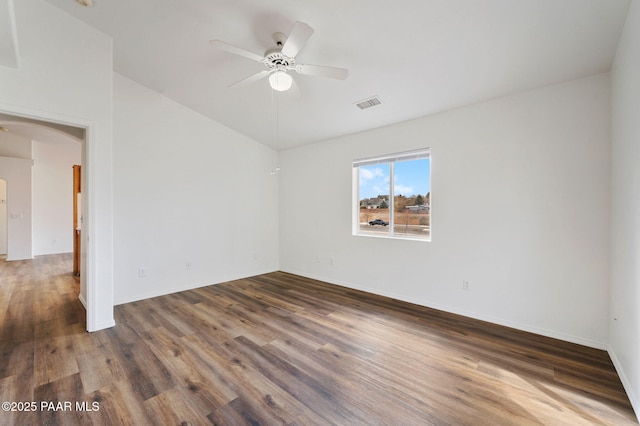 empty room with a ceiling fan, wood finished floors, visible vents, arched walkways, and vaulted ceiling