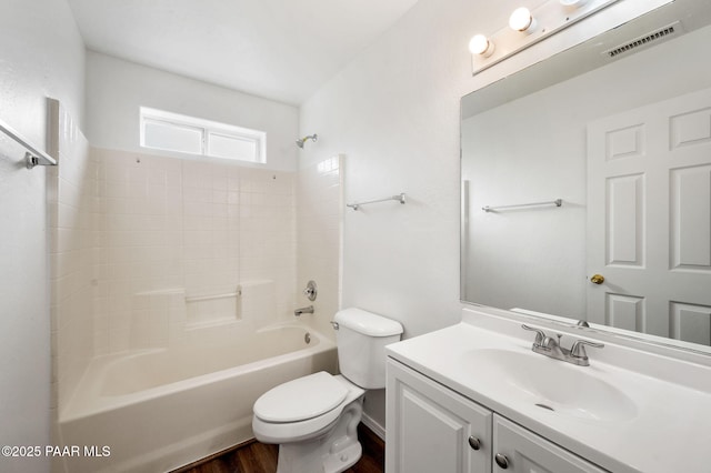 full bath with visible vents, toilet, wood finished floors, shower / bathing tub combination, and vanity