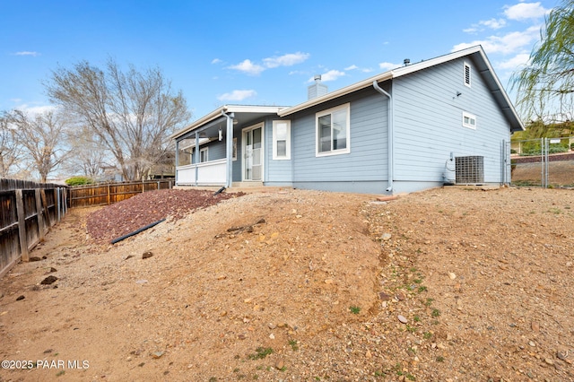 back of property with a fenced backyard and a chimney