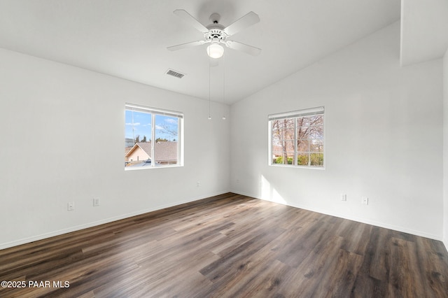 spare room featuring a ceiling fan, visible vents, baseboards, lofted ceiling, and dark wood-type flooring