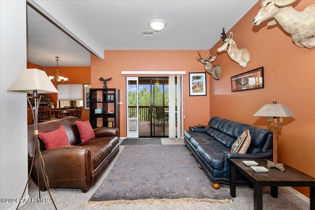 carpeted living room with beamed ceiling and a chandelier