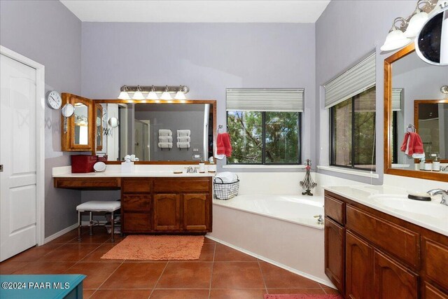 bathroom with tile patterned floors, vanity, and a tub to relax in