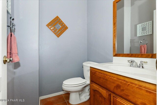 bathroom with tile patterned flooring, vanity, and toilet