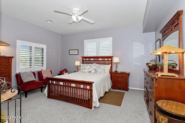 carpeted bedroom featuring multiple windows and ceiling fan