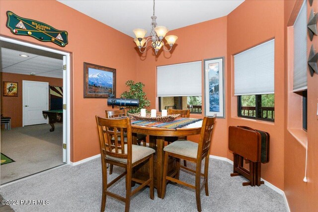 dining area with carpet and a chandelier