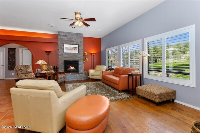 living room with ceiling fan, wood-type flooring, and a fireplace