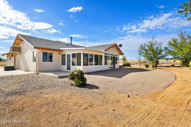 rear view of property featuring a patio, central air condition unit, a sunroom, and stucco siding