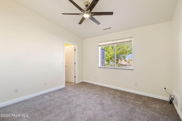 spare room with visible vents, baseboards, ceiling fan, vaulted ceiling, and carpet flooring