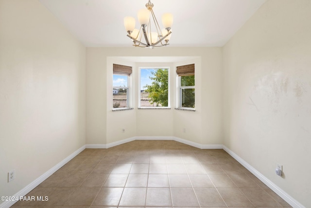 unfurnished room featuring light tile patterned flooring and a chandelier