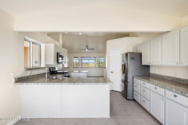 kitchen featuring white cabinetry, kitchen peninsula, stainless steel appliances, and vaulted ceiling