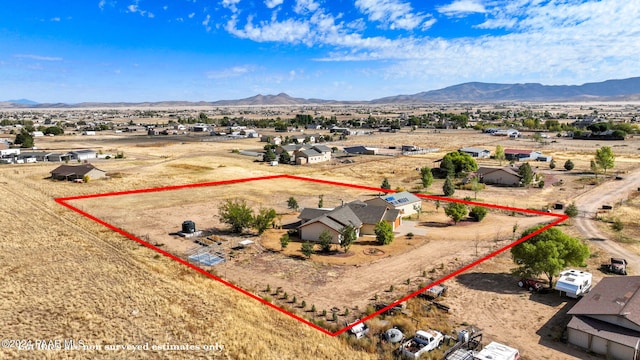 drone / aerial view featuring a mountain view, a desert view, and a rural view