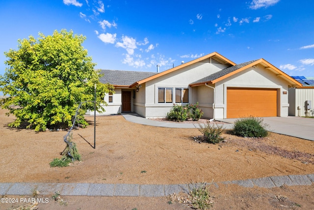 ranch-style house featuring a garage, driveway, a shingled roof, and stucco siding