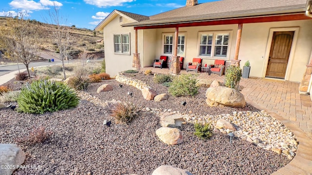 4374 Hornet Dr, Prescott, AZ 86301 - view of front facade featuring stucco siding, an outdoor living space, a chimney, a patio area, and a shingled roof