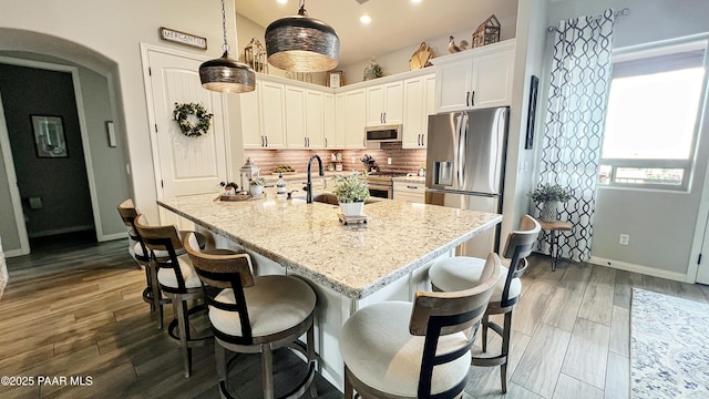 4374 Hornet Dr, Prescott, AZ 86301 - kitchen featuring stainless steel appliances, baseboards, white cabinetry, a sink, and arched walkways