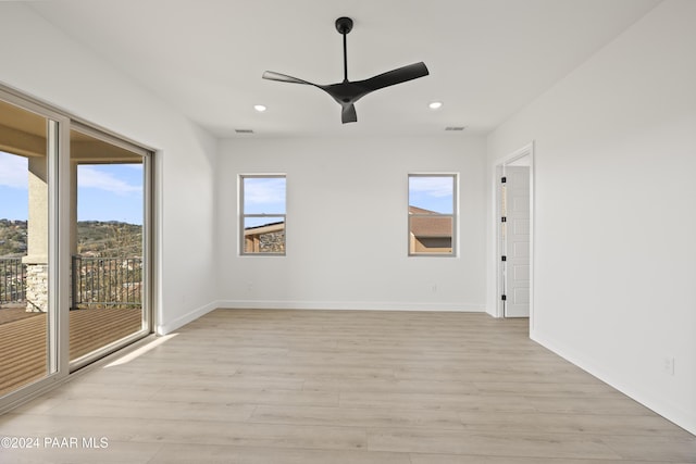 unfurnished room with light wood-type flooring, a wealth of natural light, and ceiling fan