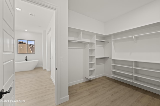 spacious closet featuring light hardwood / wood-style floors