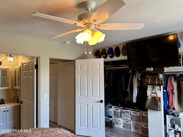 bedroom with sink, a textured ceiling, hardwood / wood-style floors, and ceiling fan