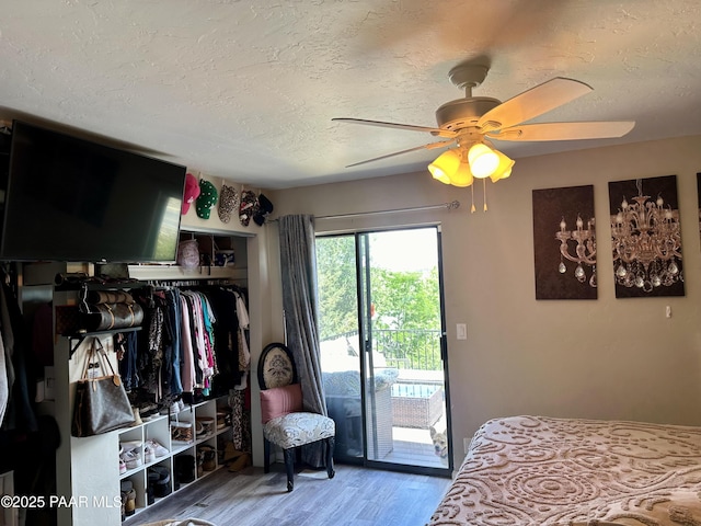 bedroom featuring access to exterior, hardwood / wood-style flooring, a textured ceiling, and ceiling fan