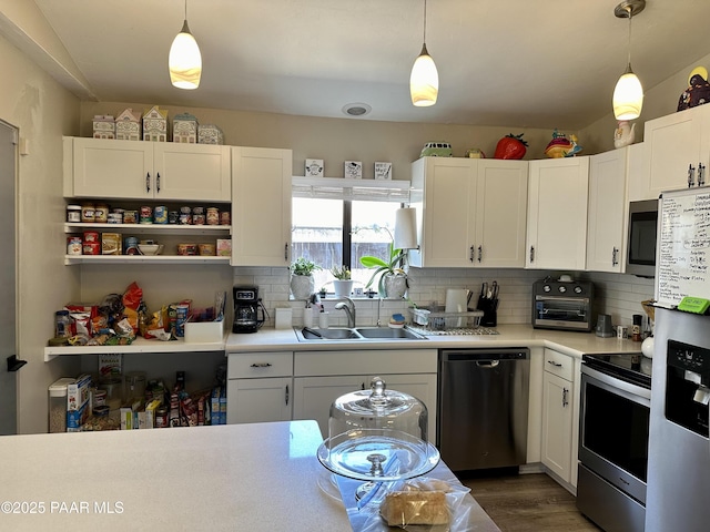 kitchen with white cabinetry, appliances with stainless steel finishes, sink, and pendant lighting