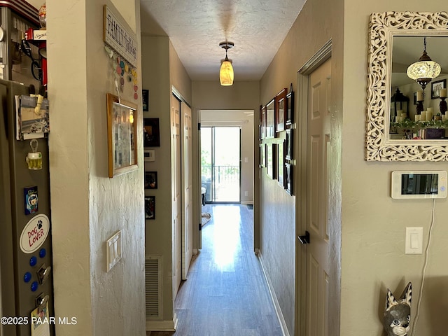 hall featuring hardwood / wood-style floors and a textured ceiling