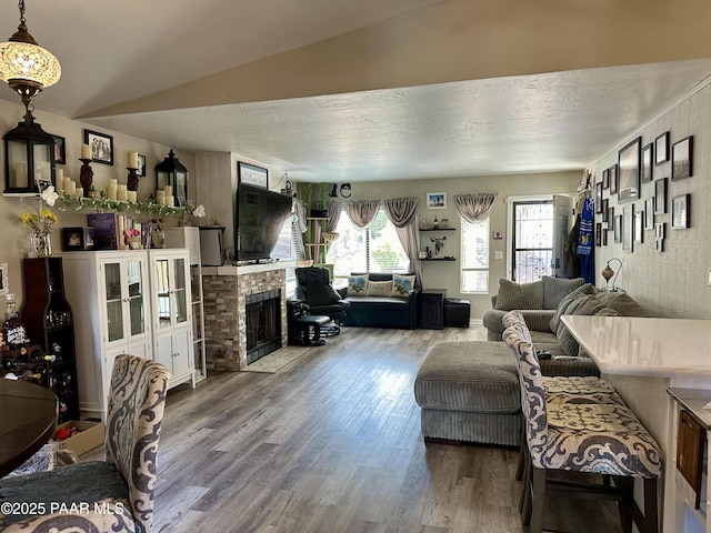 living room featuring hardwood / wood-style flooring, a fireplace, and vaulted ceiling